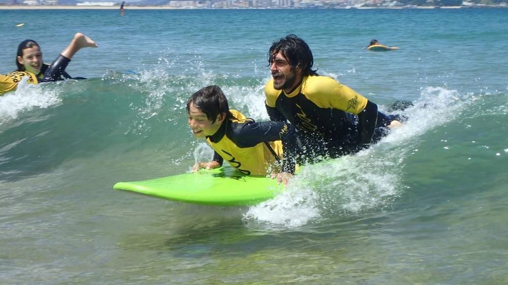 Monitor enseñando surf a un alumno